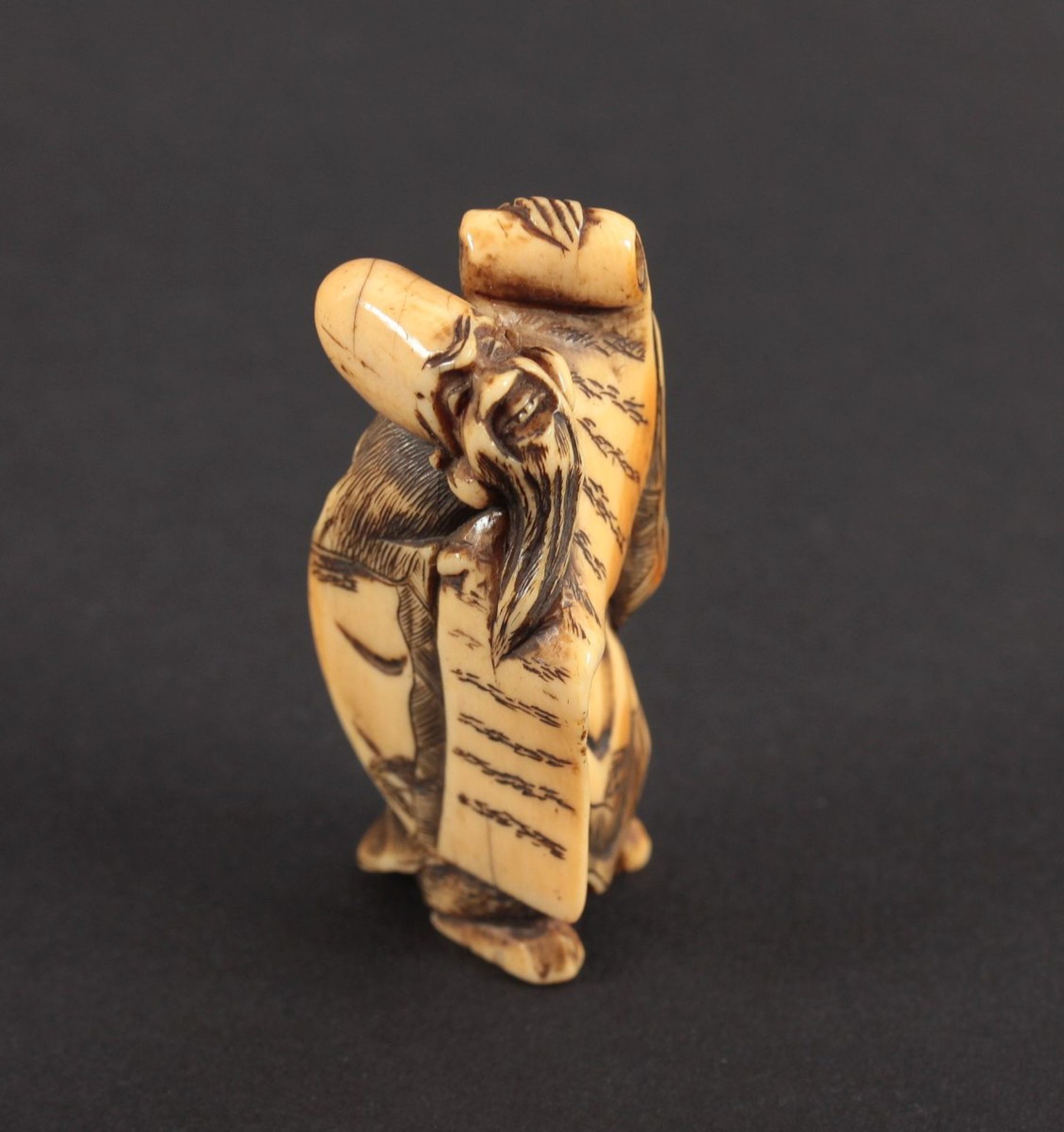 NETSUKE FUKUROKUJU, Elfenbein, fein akzentuiert geschnitzte Arbeit in Dreiecksform, schöne goldgelbe