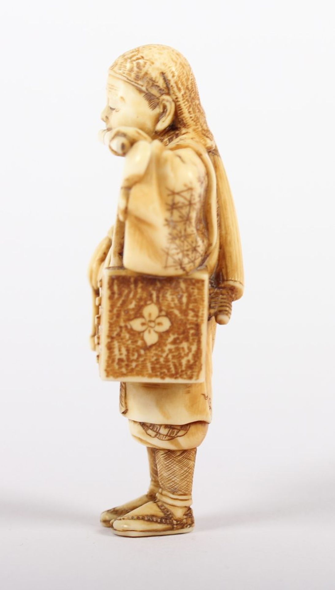 NETSUKE MUSIKER, Elfenbein, in einem kurzen Mantel gekleidet, mit der Linken hält er eine Flöte - Bild 3 aus 5