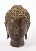 KOPF EINES BUDDHA, Bronze mit Resten von Vergoldung, große Buckellocken, das Flammenornament über