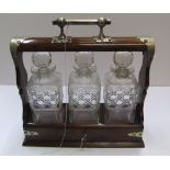 3 Bottle Edwardian tantalus, with key 36 cm in length The bottles all have large chips to the