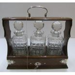 3 bottle Edwardian Tantalus, with key 35 cm long The bottles all have small chips to the neck, the