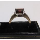 9ct gold ring with a princess cut garnet and with diamonds on each shoulder Approx 3.6 grams