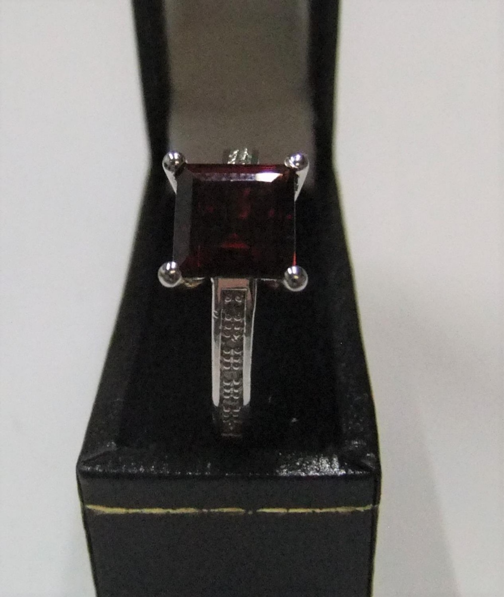 9ct gold ring with a princess cut garnet and with diamonds on each shoulder Approx 3.6 grams - Image 2 of 3