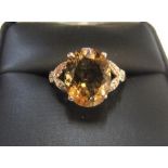 9ct yellow imported gold ring set with a large oval cut citrine set with diamonds to either flank