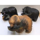 3 Black Forest bears with salmon, 2 in dark wood, the other tan coloured Approx 33 cm long by 21