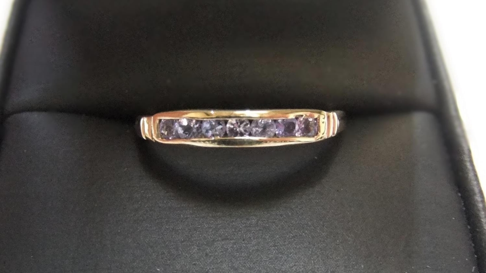 9ct yellow imported gold band ring set with 7 round cut Tanzanite Approx 1.1 grams gross, size N