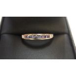 9ct yellow imported gold band ring set with 7 round cut Tanzanite Approx 1.1 grams gross, size N