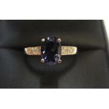 9ct yellow imported gold ring set with an oval cut iolite and with small diamonds set to the