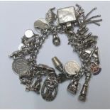 Old silver charm bracelet adorned with approx 33 silver charms and an EPNS nurses' belt buckle The