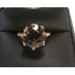 9ct yellow imported gold ring set with a large oval cut smokey topaz and with a small diamond set to