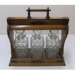 Early 20thC oak cased, unmarked, 3 bottle tantalus The tantalus is 27 cm in length No key and one of