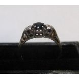 18ct yellow gold ring set with a round cut sapphire between 2 diamonds Approx 2.6 grams gross,