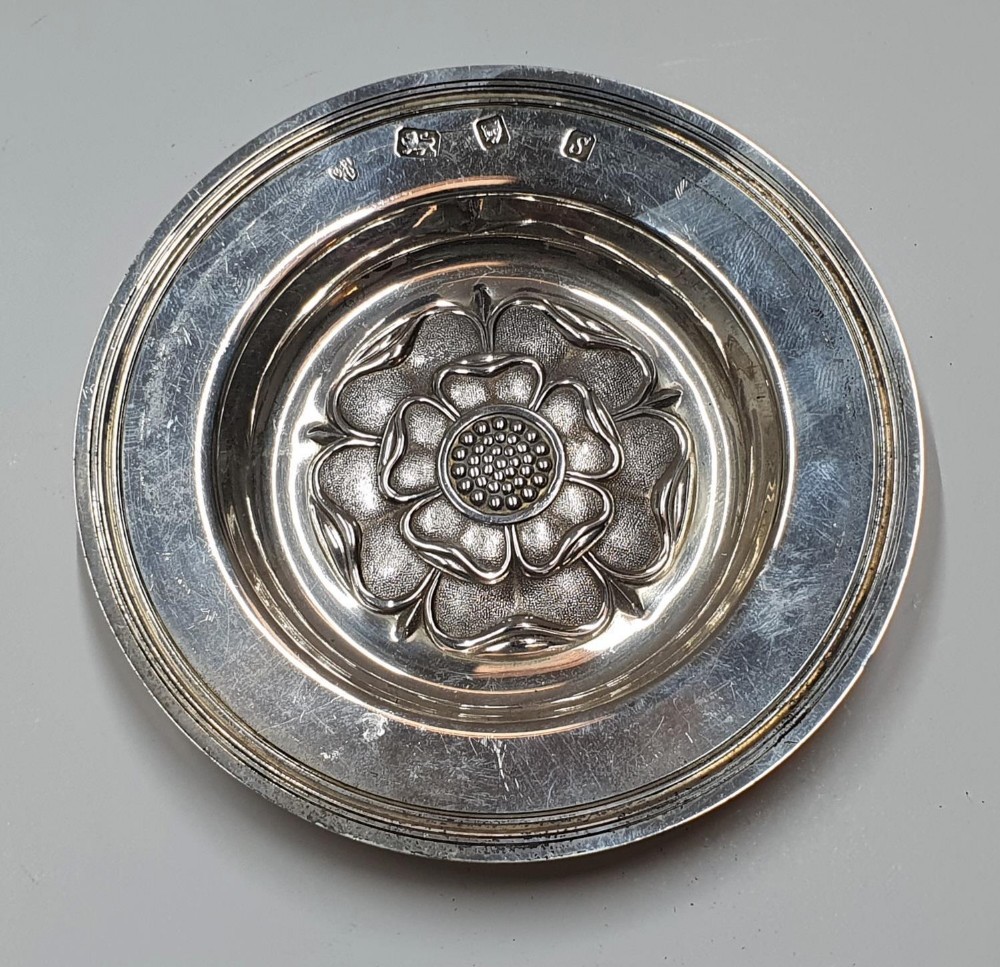 Hallmarked 20thC circular silver dish embossed with the English rose and extensively engraved to
