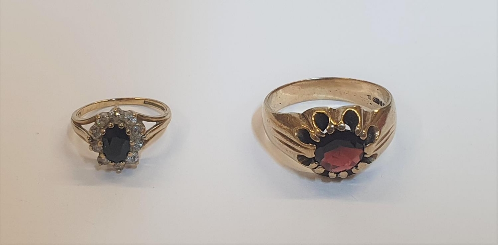 2 yellow gold rings, 1 a heavy garnet solitaire, the other a Sapphire dress ring flanked by CZ (