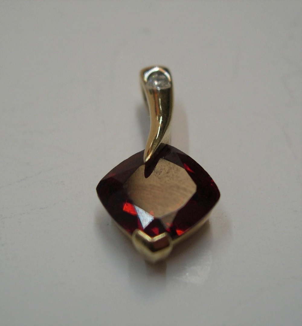 9ct yellow gold & garnet pendant below a clear stone