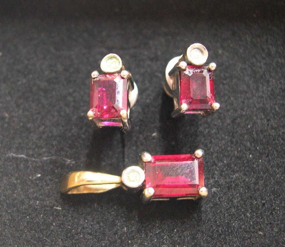 Art nouveau, matching set of earrings and pendant, all set with a baguette cut ruby below a circular