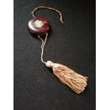 1920's plastic compact with fabric tassel and chinese style design to front 2½"diameter