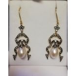 Pair of ornate drop earrings set with diamonds and a suspended pearl