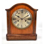 An early 20th century mahogany cased mantel clock, the silvered circular dial set with Roman