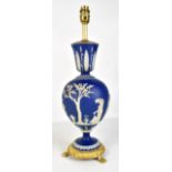 WEDGWOOD; a blue jasper dip relief decorated lamp with gilt metal mounted base and fitments,