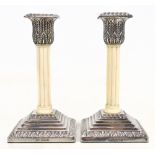 WALKER & HALL; a pair of Victorian hallmarked silver candlesticks with foliate detail and carved