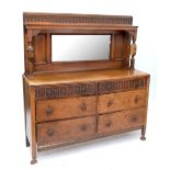 A 1920s oak mirror back sideboard with arrangement of six drawers raised on bun feet, height
