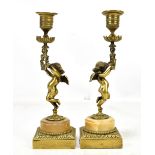 A pair of late 19th century bronze figural candlesticks with columns modelled as cupids on alabaster