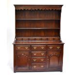 A reproduction oak dresser with plate rack back, with an assortment of seven spice drawers, six