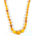 A graduated amber coloured beaded necklace, the largest bead approx 3cm, approx 84.9g.