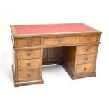 A 19th century pollard oak kneehole desk with an arrangement of nine drawers raised on plinth