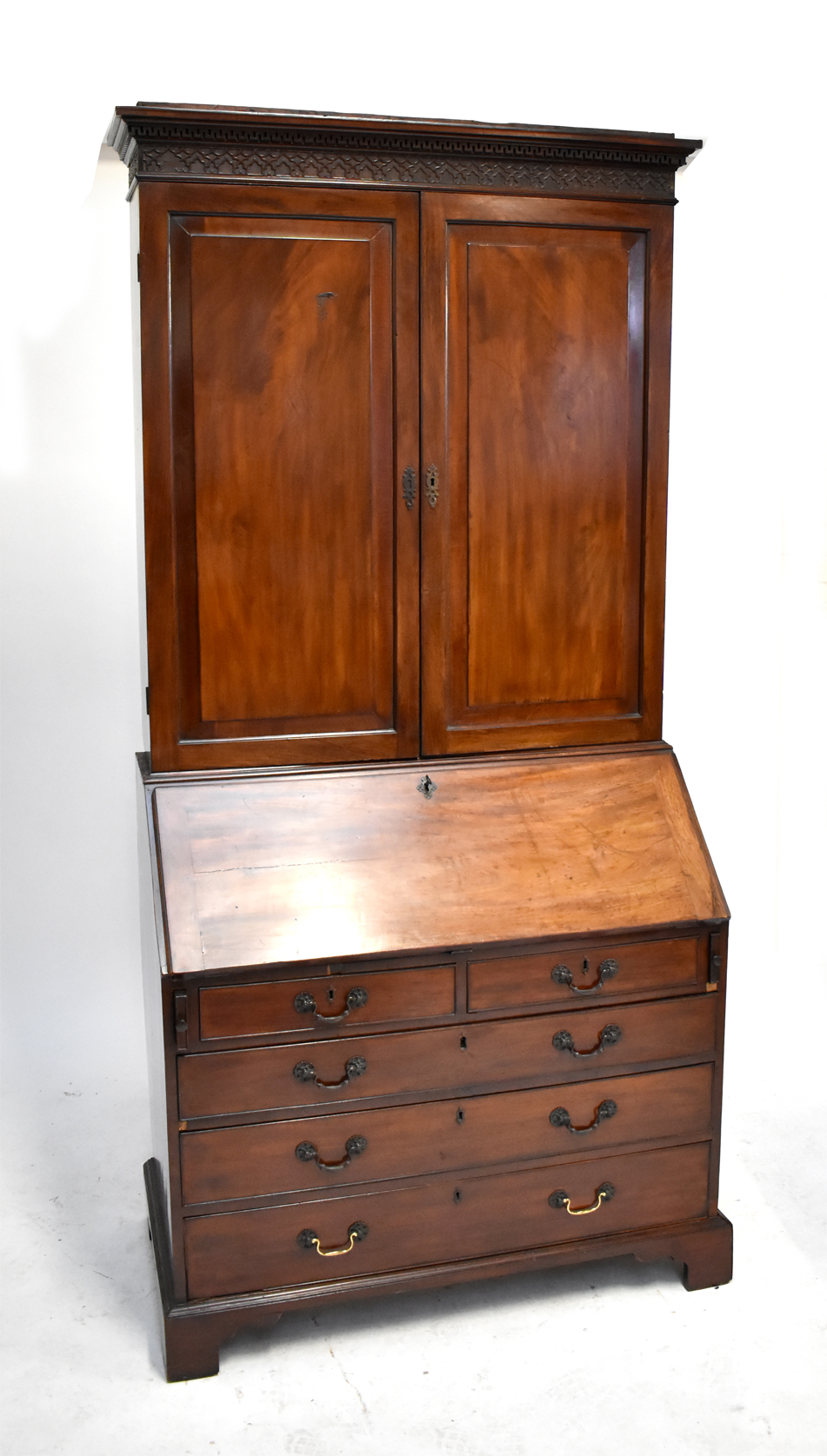 A Victorian mahogany bureau bookcase, the twin panel cupboard doors above fall front, two short