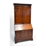 A Victorian mahogany bureau bookcase, the twin panel cupboard doors above fall front, two short