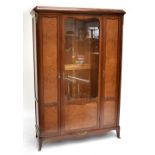 A large French mahogany and amboyna display cabinet, the central glazed door enclosing an