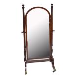 A large and impressive George IV mahogany and ebony strung cheval mirror, the arched plate held by