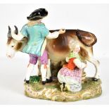 A late 19th century Continental porcelain group depicting a pair of figures milking a cow, painted
