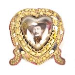 A Victorian heart shaped photograph frame, set with sea shells featuring glazed aperture enclosing