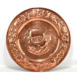 An Arts & Crafts copper wall charger of circular form, with repoussé decoration throughout with a