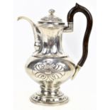 A late 19th century German silver lidded ewer with stylised repoussé detail and shaped wooden handle