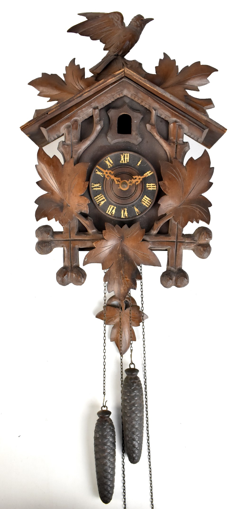 A circa 1900 Black Forest carved stained beech cuckoo clock featuring leaf and bird decoration