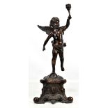 A reproduction bronze figural candlestick modelled in the form of a winged cherub raised on a