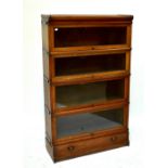 GLOBE-WERNICKE CO LTD; an oak four section stacking bookcase with glazed hinged doors above single