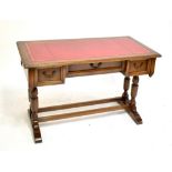 A reproduction oak flat top desk, with red leather inset top and two drawers, width 122cm.
