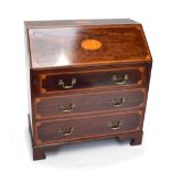 An Edwardian Sheraton Revival inlaid mahogany bureau, the fall-front enclosing fitted interior above