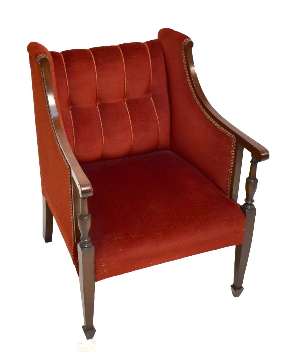 An Edwardian upholstered square sectioned tub chair.
