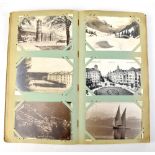 An early 20th century postcard album to include topographical and other cards.