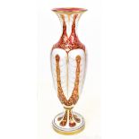 A large 19th century Bohemian ruby glass baluster vase featuring opaque white enamel and gilt floral