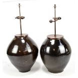 A pair of Chinese dark brown glazed ovoid table lamps, each with twin sockets and box pleated