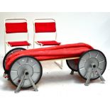 A unique bench made from a fireman's hose and wheel, length 142cm, a green garden bench, length