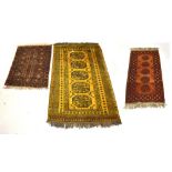 A large Middle Eastern mustard ground rug, approx 200 x 120cm, and two further smaller examples (