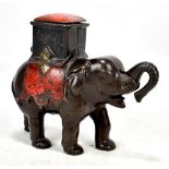 A 19th century cast iron money box modelled as an elephant and driver with sprung lid and trunk, box